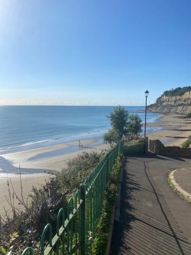 a path to a beach with a fence and the ocean at The Bay house Apartments , shanklin in Shanklin