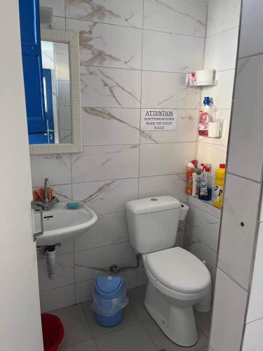 a white bathroom with a toilet and a sink at Panorama in Parikia