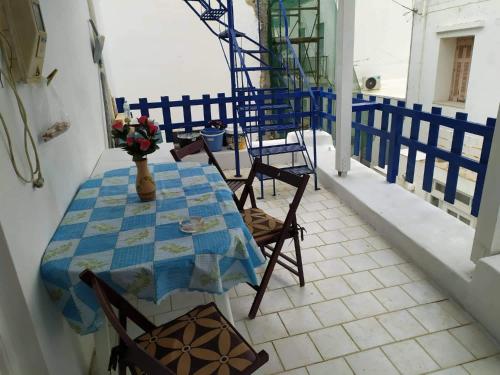 una mesa con sillas y un jarrón de flores en el balcón en Panorama, en Parikia