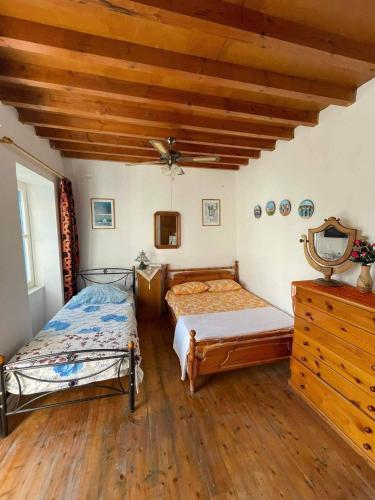 a bedroom with two beds and a wooden ceiling at Panorama in Parikia