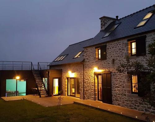 a brick house with a patio and a staircase at Ty Marie Neiz Vran - Villa luxe vue mer, 80 mètres de la plage in Kerlouan