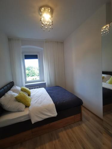 a bedroom with a bed with yellow pillows and a window at K&Scielna4013 in Świdnica