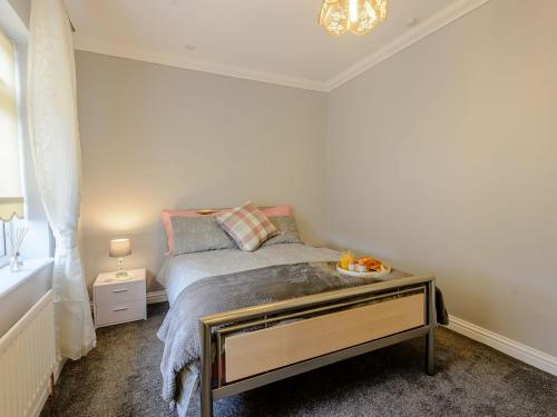 a small bedroom with a bed and a table at Fletchers Rest in Cawston