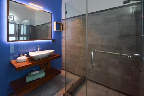 a bathroom with a sink and a glass shower at Bless Villa Apartment in Kiwengwa