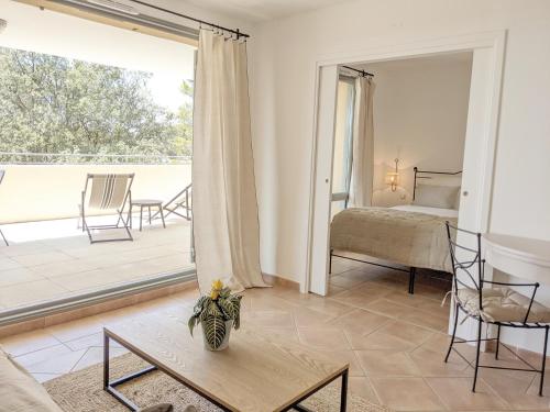 ALLURA GOLF APPARTEMENT في Saumane-de-Vaucluse: غرفة معيشة مع سرير وطاولة