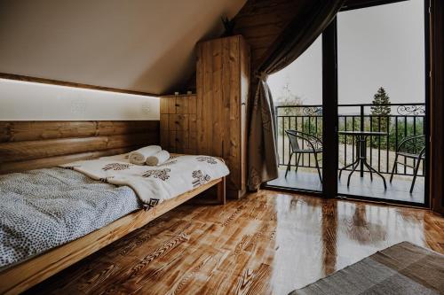 ein Schlafzimmer mit einem Bett und einem großen Fenster in der Unterkunft Leśne Zacisze in Nowy Targ