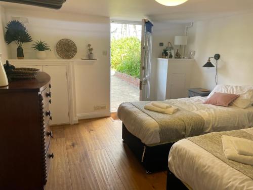 1 Schlafzimmer mit 2 Betten und einer Tür zum Hof in der Unterkunft NomiHomes-Otis House-Free Parking x 2-Central -10ppl in Exeter