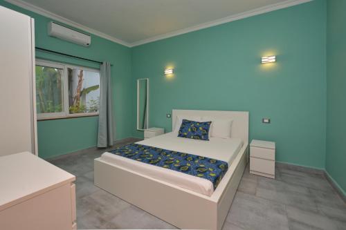 1 dormitorio con 1 cama con pared azul en Bless Villa Apartment en Kiwengwa