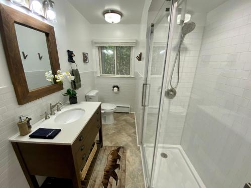 a white bathroom with a shower and a sink at Escape to a 3-Bedroom Cabin in Lower Catskills in Woodridge