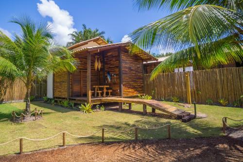 una casa de madera con una valla y un patio en Cabana Fluir - Taipu de Fora - Península de Maraú en Barra Grande