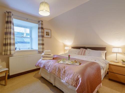 a bedroom with a bed with towels on it at Little Arches - S4665 in Lochwinnoch
