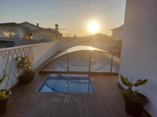 a swimming pool on a balcony with the sun setting at Casa do Martins in Esposende