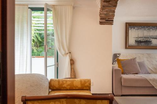 a living room with a couch and a window at Casa da Adôa B&B in Portinho da Arrábida