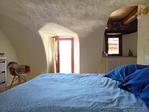 um quarto com uma cama azul e uma janela em Casa Vacanze Nebin em Stroppo