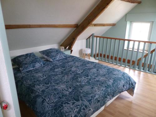 a bedroom with a bed with a blue blanket at Jolie maison pour 4 à 6 personnes in Ellon