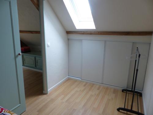 an attic room with a skylight and white cabinets at Jolie maison pour 4 à 6 personnes in Ellon