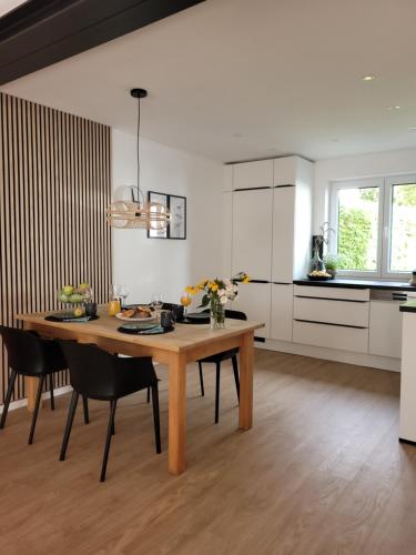 a kitchen and dining room with a wooden table and chairs at Ferienwohnung Anna Maria Erding in Erding