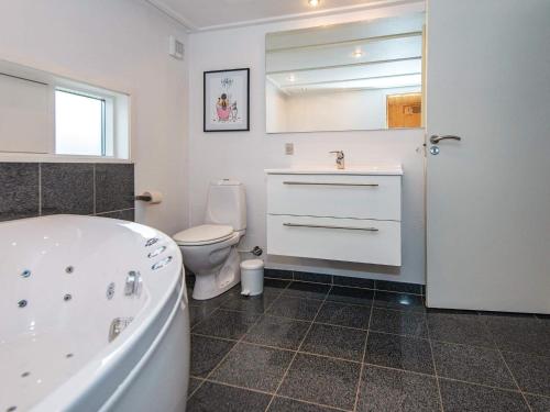 y baño con bañera, aseo y lavamanos. en Three-Bedroom Holiday home in Aabenraa 3, en Loddenhøj