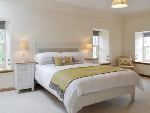 a bedroom with a large white bed with two windows at The Stables - Uk11108 in Montrose