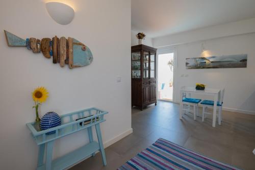 a living room with a blue table and a desk at Casa no Rio - River House in Vila Nova de Milfontes