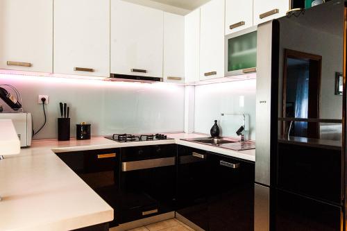 a kitchen with black and white cabinets and a sink at ARENA in Osijek