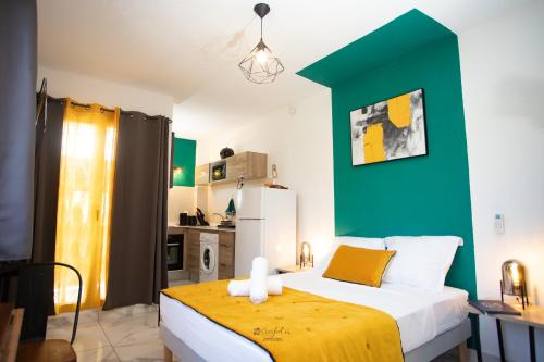 1 dormitorio con cama y pared verde en Le Jardin Secret Guyanais avec Piscine et Jardin de 70 m2, en Cayenne