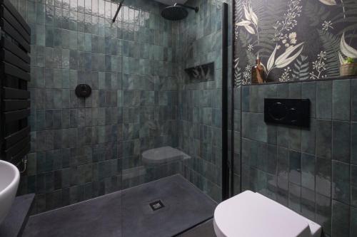 a bathroom with a shower with a toilet and a sink at Honeysuckle Lodge in Knaresborough