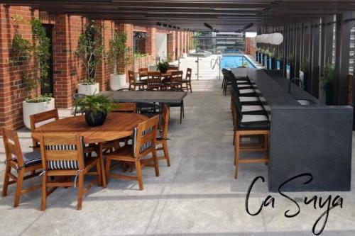 a patio with tables and chairs and a pool at CaSuya Airali apartments with heated pool, gym in city center in Guatemala