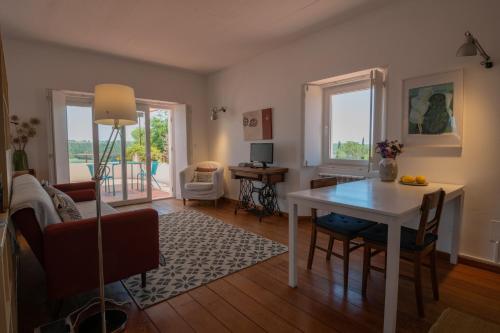 a living room with a table and a couch at Casa no Rio - River House in Vila Nova de Milfontes