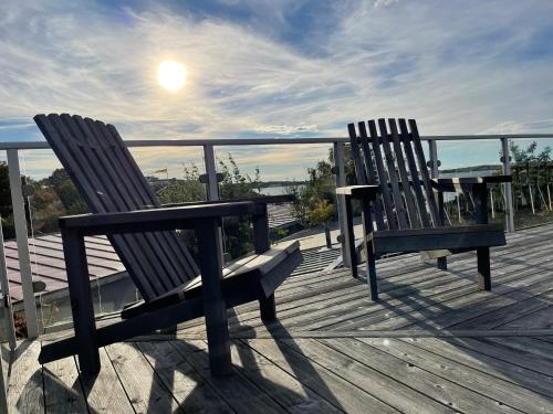 two benches sitting on a deck looking out at the water at Sillvik C&J Hugosson in Sanden