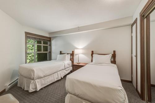 a room with two beds and a window at Blackcomb Springs Suites by CLIQUE in Whistler