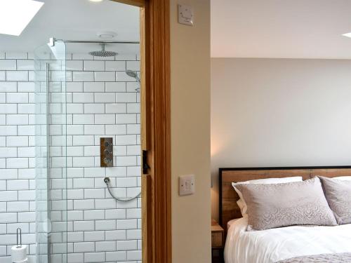 a bedroom with a bed and a glass shower at Lake View Farm in Watermillock