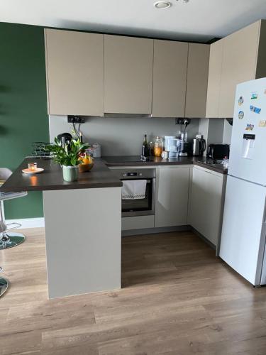 a kitchen with white cabinets and a white refrigerator at Lovely and comfortable flat in Chelsea. in London