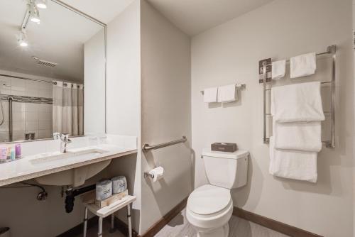 a white bathroom with a toilet and a sink at Blackcomb Springs Suites by CLIQUE in Whistler