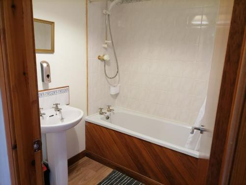 ein Badezimmer mit einem Waschbecken, einer Badewanne und einem WC in der Unterkunft Impeccable 2-Bed Flat in Wick in Wick