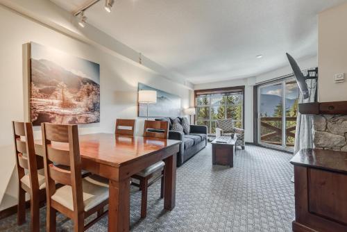 a living room with a table and a couch at Blackcomb Springs Suites by CLIQUE in Whistler