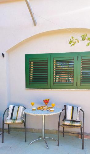 a table and two chairs with drinks on it at Apartments Marija Karlobag in Karlobag