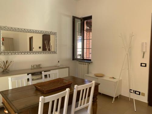 uma sala de jantar com uma mesa e um espelho em La Casetta Rosa em Travacò Siccomario