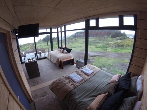 uma vista para um quarto com 2 camas e uma televisão em Cabañas Tierra Salada em Cáhuil