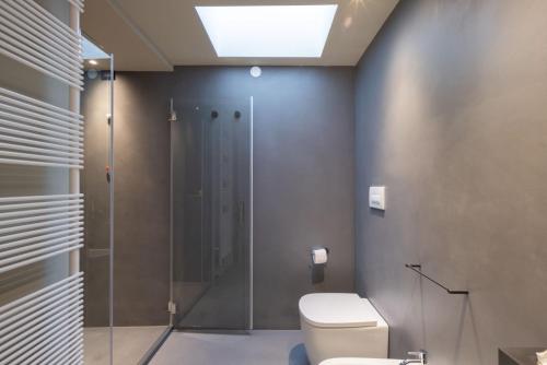 a bathroom with a toilet and a glass shower at VIS Urban Suites&Spa in Bari