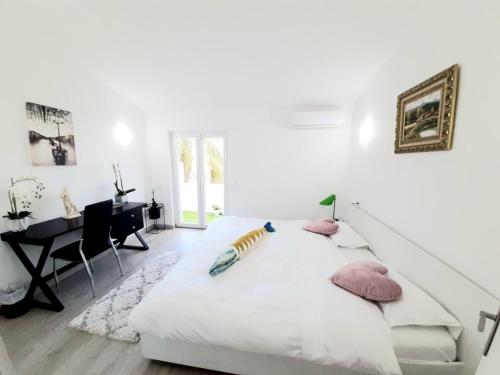 een witte slaapkamer met een bed en een bureau bij Alojamento local "CASA BRANCA" in Albufeira