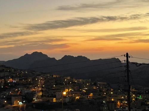 a city lit up at night with mountains in the background at Petra Guests Hotel in Wadi Musa