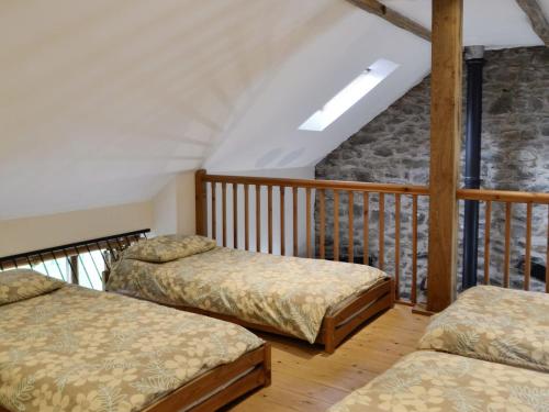 a room with three beds on a balcony at The Hen House in Llanfair-ar-y-bryn