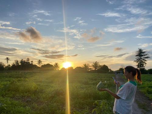 a woman standing in a field with a kite at Belvedere Thoddoo in Thoddoo
