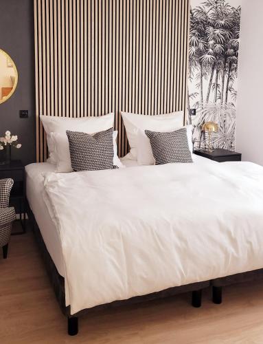a bedroom with a large bed with white sheets and pillows at Ferienwohnung Anna Maria Erding in Erding