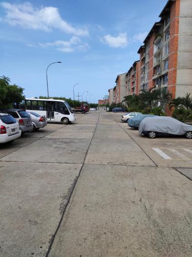 a parking lot with parked cars and a bus at Apartamento Aeropuerto Maiquetia en Planta Baja in Catia La Mar