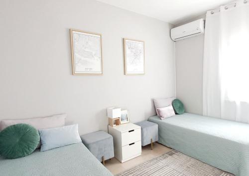 een slaapkamer met 2 bedden, een stoel en een raam bij Feliz Algarve in Albufeira