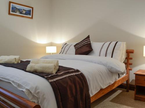 sypialnia z dużym łóżkiem z 2 poduszkami w obiekcie Three Rivers Cottage w mieście Pont-Nedd-Fechan