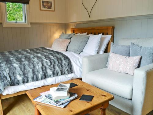 a bedroom with a bed and a couch and a table at Caban Caru in Dinas Mawddwy