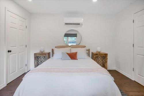 ein weißes Schlafzimmer mit einem großen weißen Bett mit Kissen in der Unterkunft Relaxing Alpaca Ranch Mins from Downtown Wimberley in Wimberley